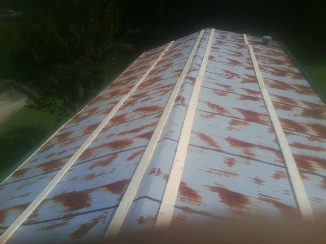 Rusted metal roof panels with new wood purlins before replacement — Storm Damage Roof Repair in Glassport by Roofing Brothers