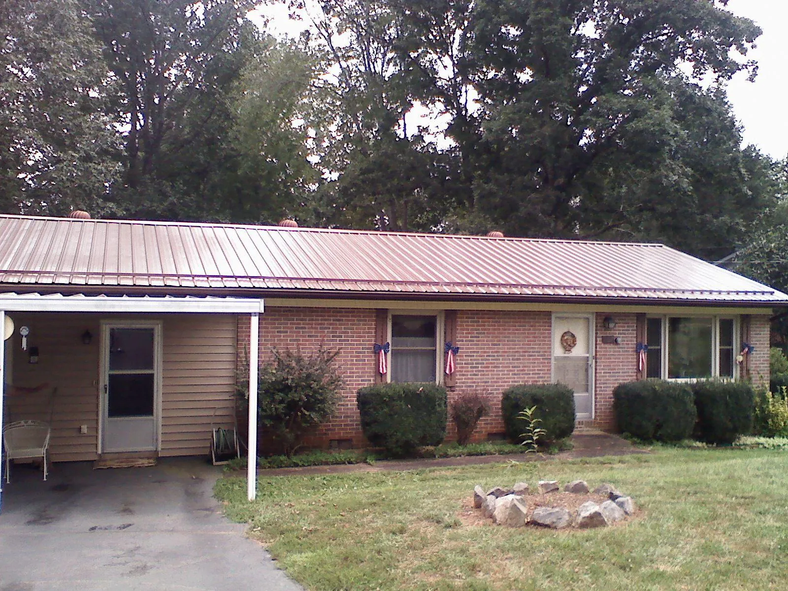 Bronze metal roof and carport on a brick ranch home — Roof Repair work by our crew in Glassport